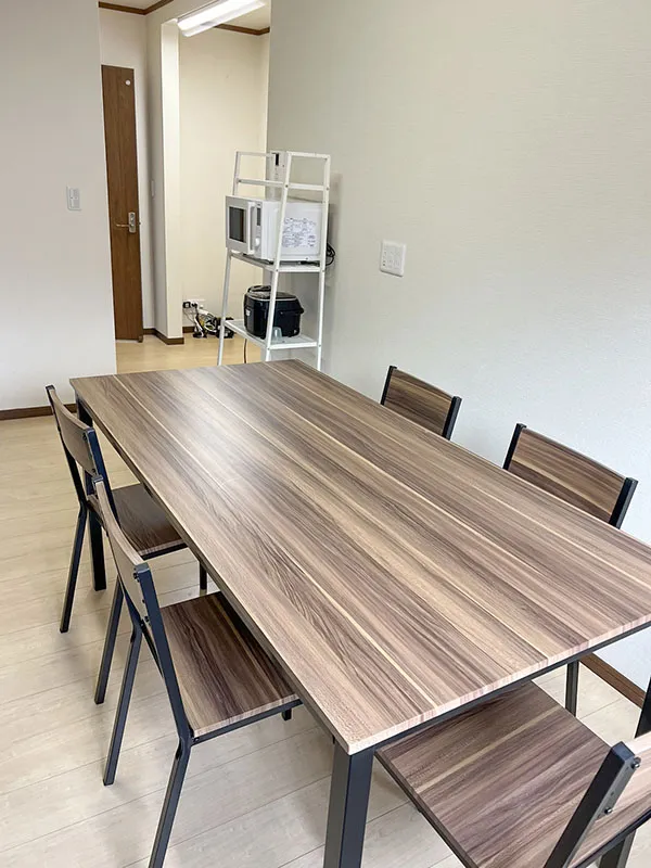 障がい者グループホームしらゆりケア こゆり智積の共有部分。木目のテーブルが並ぶ